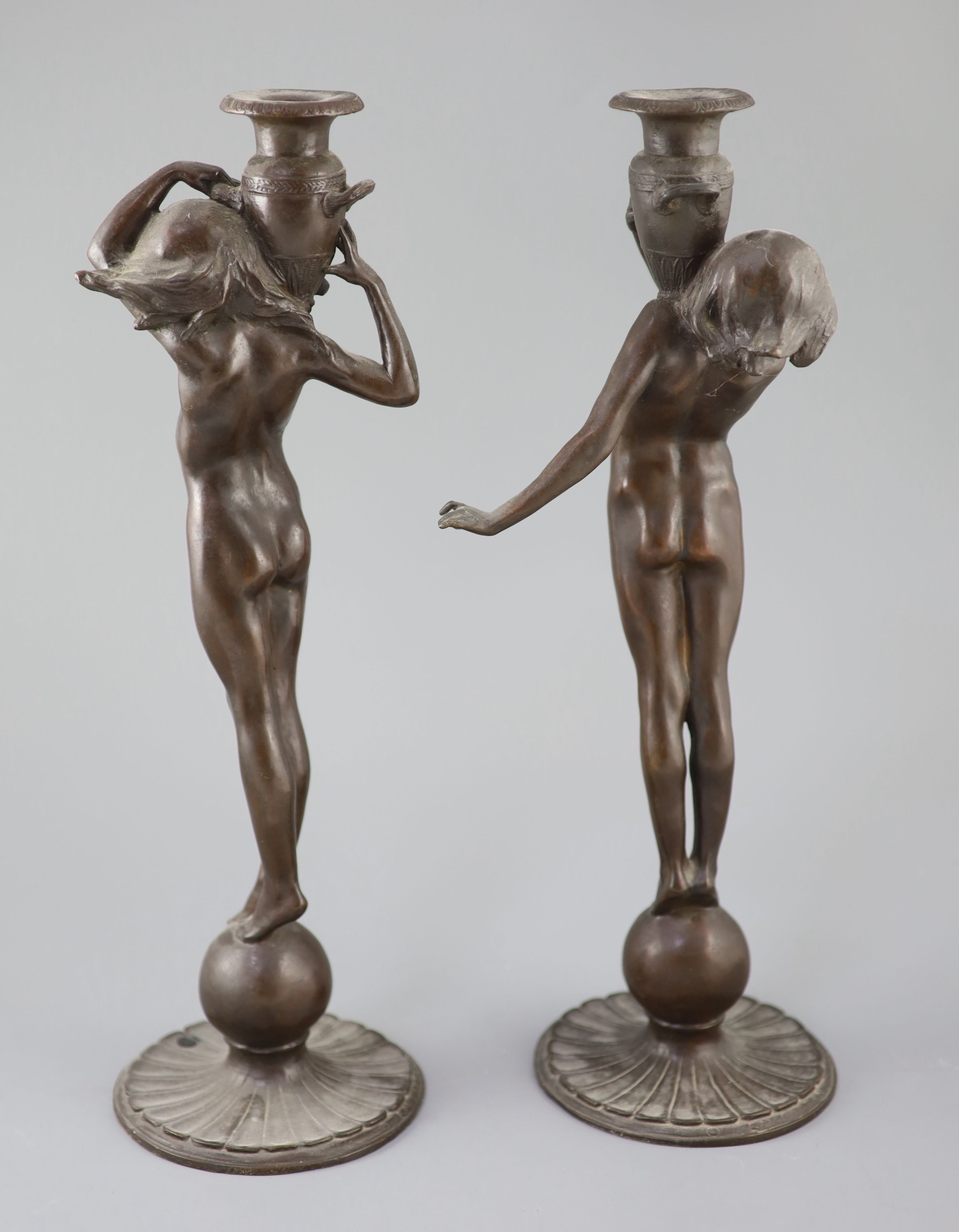 After Edward Francis McCartan (1879-1947). A pair of Art Nouveau bronze candlesticks, height 16.75in.